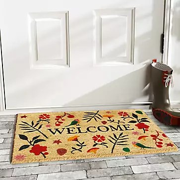 Photo of a welcome mat with flowers printed on it.